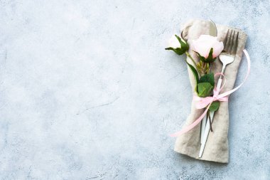 Masa seti, modern çatal bıçak takımı ve gül çiçekleri. Kopyalama alanı olan beyaz arkaplanda üst görünüm.