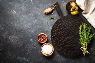 Baharat ve bitkiler, siyah arka planda kesim tahtası. Metin için boşluk ile düz uzandı.