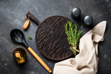 Baharat ve bitkiler, siyah arka planda kesim tahtası. Kopyalama alanı olan üst görünüm.