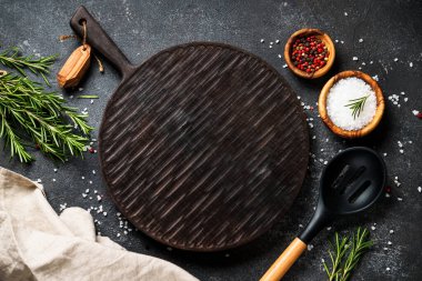 Baharat ve bitkiler, siyah arka planda kesim tahtası. Metin için boşluk ile düz uzandı.