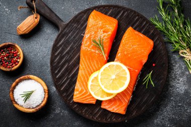 Siyah masada çiğ balık. Limon ve baharatlı somon filetosu. Düz yatıyordu.