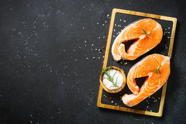 Çiğ balık, siyah arka planda taze somon bifteği..