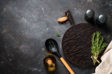 Baharat ve bitkiler, siyah arka planda kesim tahtası. Metin için boşluk ile düz uzandı.