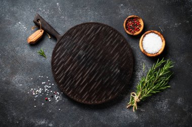 Baharat ve bitkiler, siyah arka planda kesim tahtası. Metin için boşluk ile düz uzandı.