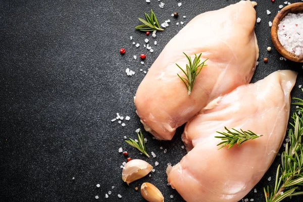 Siyah masada baharatlı pişmemiş tavuk göğsü. Metin için boşluk olan üst görünüm.