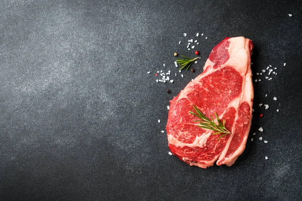 Biftek. Siyah üzerine çiğ pirzola. Kopyalama alanı olan üst görünüm.