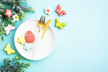 Paskalya yemeği geçmişi. Yumurtalı beyaz tabak, bahar çiçekleri ve paskalya kurabiyeleri. Düz yatıyordu.