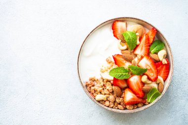 Mısır gevrekli yoğurt ve beyaz çilekli. Sağlıklı atıştırmalık ya da kahvaltı, meyve salatası. Üst görünüm.