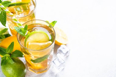 Malzemeli buzlu çay. Limonlu, limonlu, naneli ve buzlu siyah çay. Soğuk limonata, beyaz masada yaz içkisi..