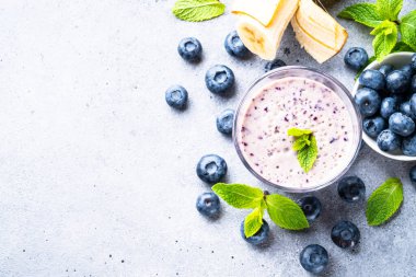 Yaban mersinli muzlu smoothie veya taze meyveli milkshake. Kopyalama alanı olan üst görünüm.