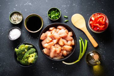 Soya soslu tavuk kızartması ve siyah arka planda sebze. Yemek pişirmek için gerekli malzemeler, tarif. Düz yatıyordu.