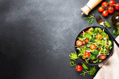 Salata yapraklı yeşil salata ve siyah arka planda sebze. Kopyalama alanı olan üst görünüm.