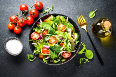 Salata yapraklı yeşil salata ve siyah arka planda sebze. Kopyalama alanı olan düz.