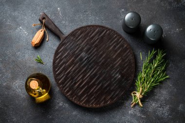 Baharat ve bitkiler, siyah arka planda kesim tahtası. Kopyalama alanı olan üst görünüm.