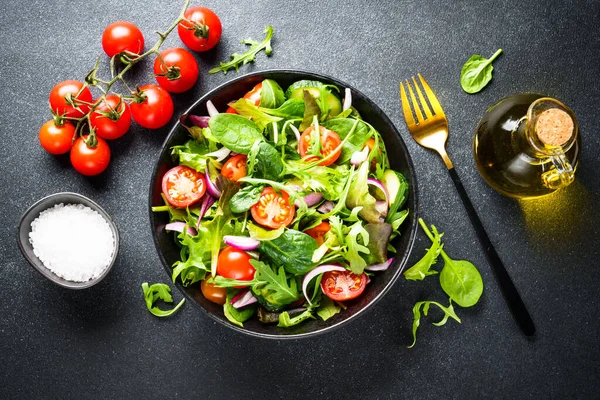Salata yapraklı yeşil salata ve siyah arka planda sebze. Kopyalama alanı olan düz.