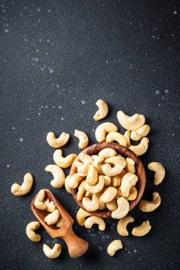 Siyah arka planda kasede kaju fıstığı. Metin için boşluk ile düz uzandı.