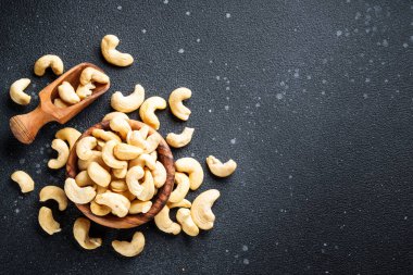 Siyah arka planda kasede kaju fıstığı. Metin için boşluk ile düz uzandı.