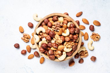 Beyaz arka planda fındık çeşitleri. Badem, fındık, ahşap kasede kaju..