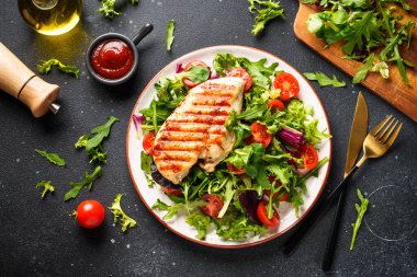 Tavuklu yeşil salata ve siyah arka planda taze sebzeler. Keto diyeti, sağlıklı yiyecekler.