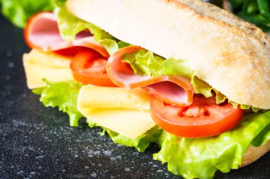 Marul, peynir, domates ve jambonlu sandviç. Sağlıklı fast food, kahvaltı ya da öğle yemeği. Kapat..