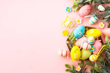 Yuvadaki paskalya yumurtaları pembe arka planda. Paskalya dekoru. Kopyalama alanı olan düz resim.