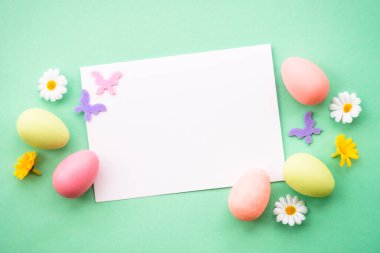 Renkli yumurta, çiçek ve kelebekli Paskalya tebrik kartı. Kopyalama alanı olan düz resim.