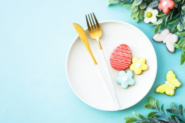 Paskalya yemeği geçmişi. Yumurtalı beyaz tabak, bahar çiçekleri ve paskalya kurabiyeleri. Düz yatıyordu.