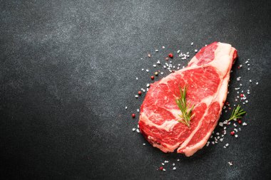 Biftek. Kurutulmuş pirzola, siyah üzerine çiğ et. Kopyalama alanı olan üst görünüm.