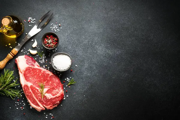 Rauwe Vlees Biefstuk Met Specerijen Zwarte Achtergrond Rundbiefstuk Ribeye Bovenaanzicht Stockfoto