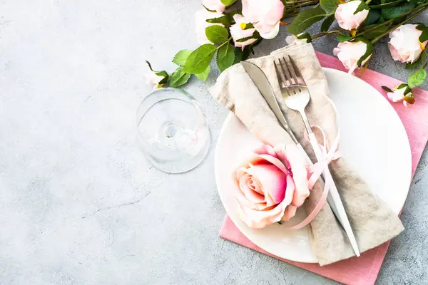 ホワイトプレート カトラリー ワイングラス ピンクの花 春のテーブルが決まりました コピースペースとフラットレイ ストックフォト
