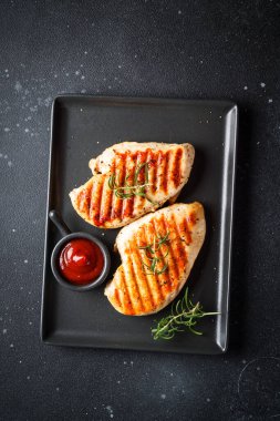 Izgara et. Baharatlı ve ketçaplı tavuk bifteği. Siyah masadaki üst görünüm.