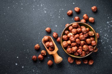 Siyah arka planda fındıklar kasede. Kopyalama alanı olan üst görünüm.