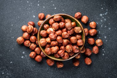 Siyah arka planda fındıklar kasede. Üst görünüm.