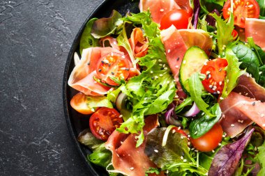 Salamlı yeşil sebze salatası ve susam. Metin için boşluk olan üst görünüm. Makro.