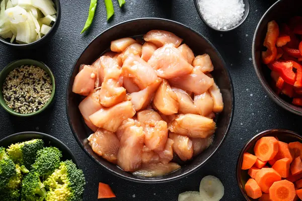 Soya soslu tavuk kızartması ve siyah arka planda sebze. Yemek pişirmek için gerekli malzemeler, tarif. Kopyalama alanı olan düz.