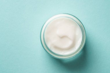 Mavi arka planda krema kavanozu. Cilt bakım ürünü. Düz görünüm.