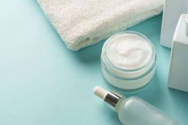 Mavi üzerine cilt bakım ürünleri. Yüz kremi, tonik, serum şişesi..