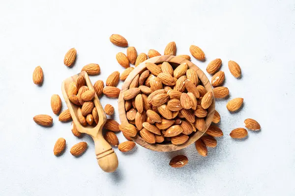 stock image Almond nuts in wooden bowl at white background.