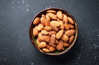 Siyah arka planda fındıklar kasede. Üst görünüm.