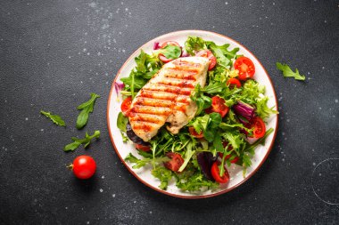Tavuklu yeşil salata ve siyah arka planda taze sebzeler. Keto diyeti, sağlıklı yiyecekler.