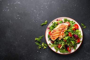 Dash diyeti, sağlıklı beslenme. Siyah arka planda taze salatalı tavuk bifteği. Kopyalama alanı olan üst görünüm.