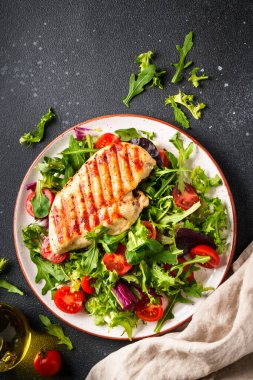 Dash diyet tabağı. Siyah arka planda taze salatalı tavuk bifteği. Kopyalama alanı olan üst görünüm.