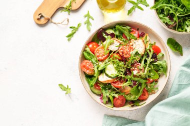 Dash diyet tarifi. Fırında tavuk göğsü, taze salata yaprakları ve sebzeli yeşil salata. Beyaz arkaplanda üst görünüm.