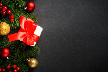 Noel arkaplanı, Noel ağacı, hediye kutusu ve siyahta tatil süslemeleri. Kopyalama alanı olan düz.