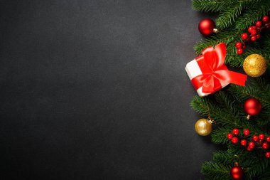 Siyah Noel arkaplanı dümdüz uzanıyordu. Şimdiki kutulu Noel ağacı ve siyahta tatil süslemeleri.