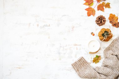 Sonbahar beyazı arka planda yatıyordu. Sıcak kazak, sonbahar yaprakları, mum ve dekor..