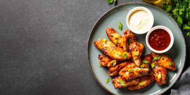 BBC soslu tavuk kanadı ızgara et. Restoran yemeği. Siyah taş masadaki üst görünüm.