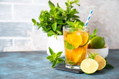 Malzemeli buzlu çay. Limonlu, limonlu, naneli ve buzlu siyah çay. Soğuk limonata, mutfak masasında yaz içkisi..