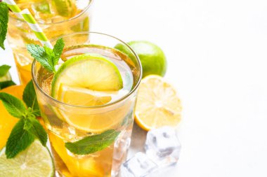 Malzemeli buzlu çay. Limonlu, limonlu, naneli ve buzlu siyah çay. Soğuk limonata, beyaz masada yaz içkisi..