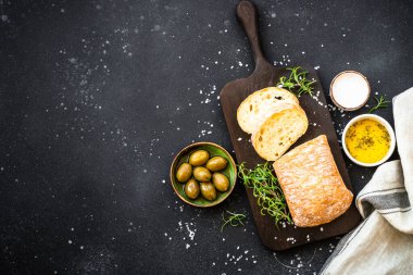 Ciabatta ekmeği, zeytinli ve siyah otlu. Akdeniz yemekleri. Kopyalama alanı olan üst görünüm.
